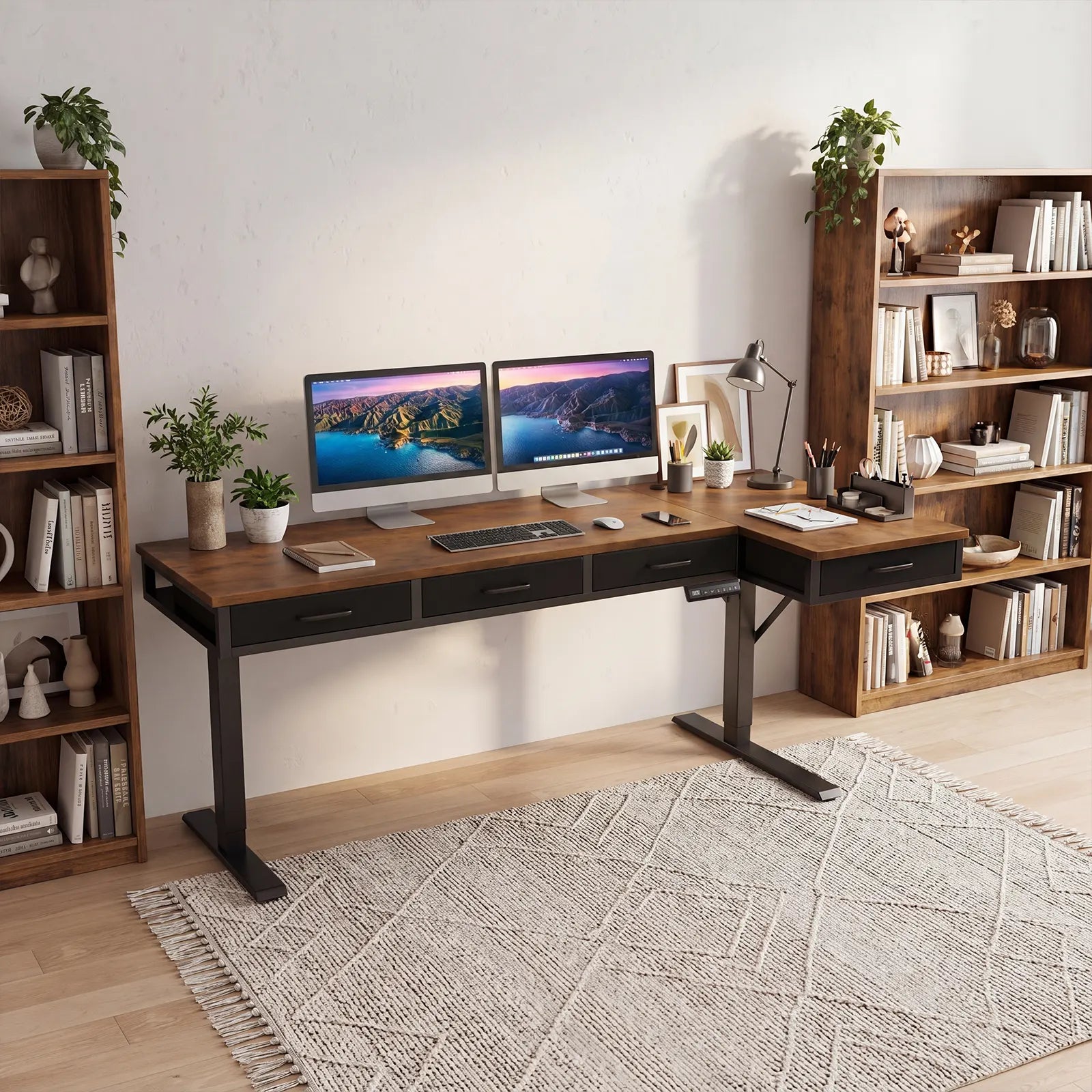 Rustic brown OffiGo L-shaped standing desk with built-in drawers, dual monitors, and organized home office bookshelf setup.