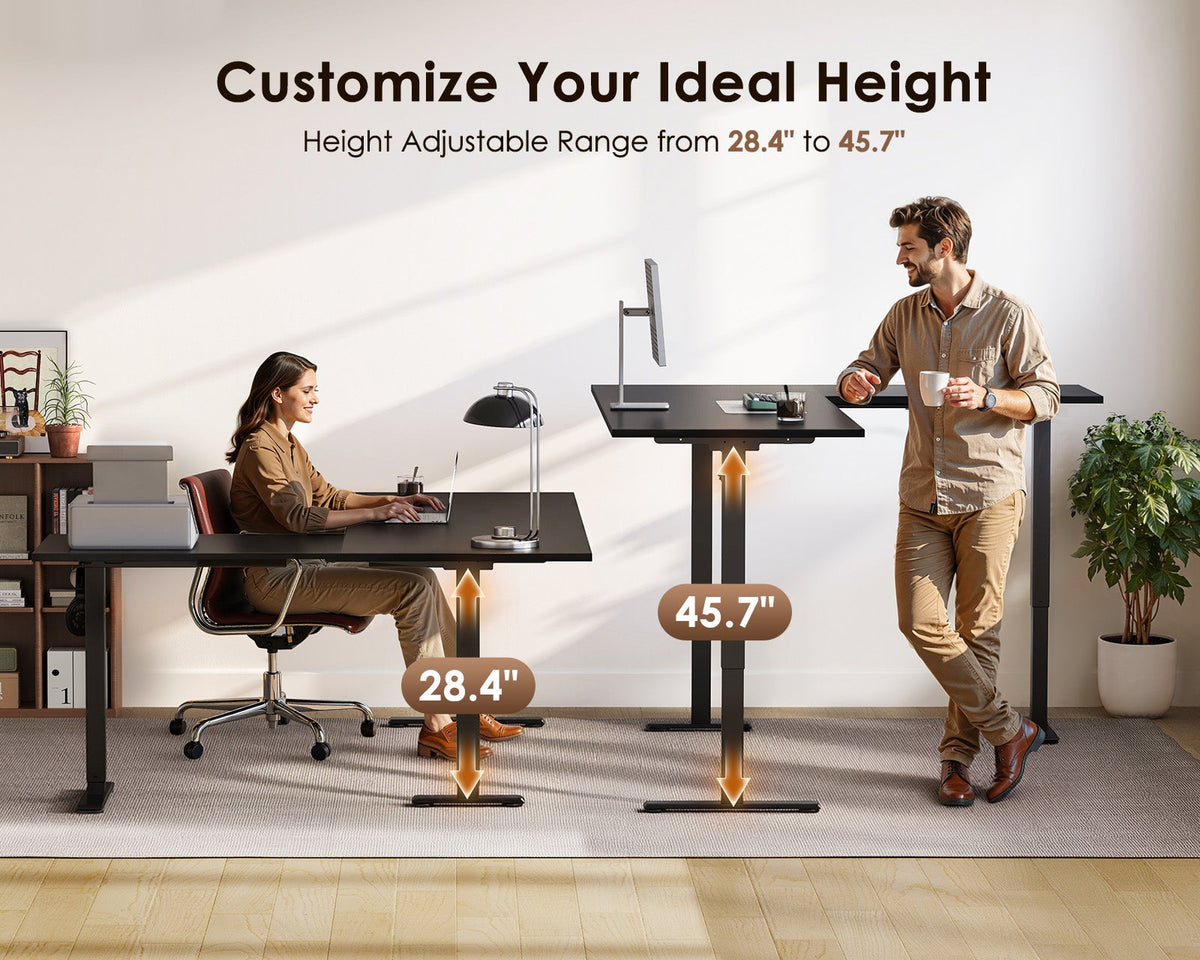 Seated and standing users at the OffiGo black L-shaped electric standing desk, illustrating the 28.4 to 45.7-inch height adjustment range.