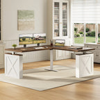 OffiGo 63-inch farmhouse L-shaped standing desk with a walnut-brown desktop, white X-brace side panels and a white center support leg, arranged in a bright home office with dual monitors, a laptop and a printer beside white bookcases.