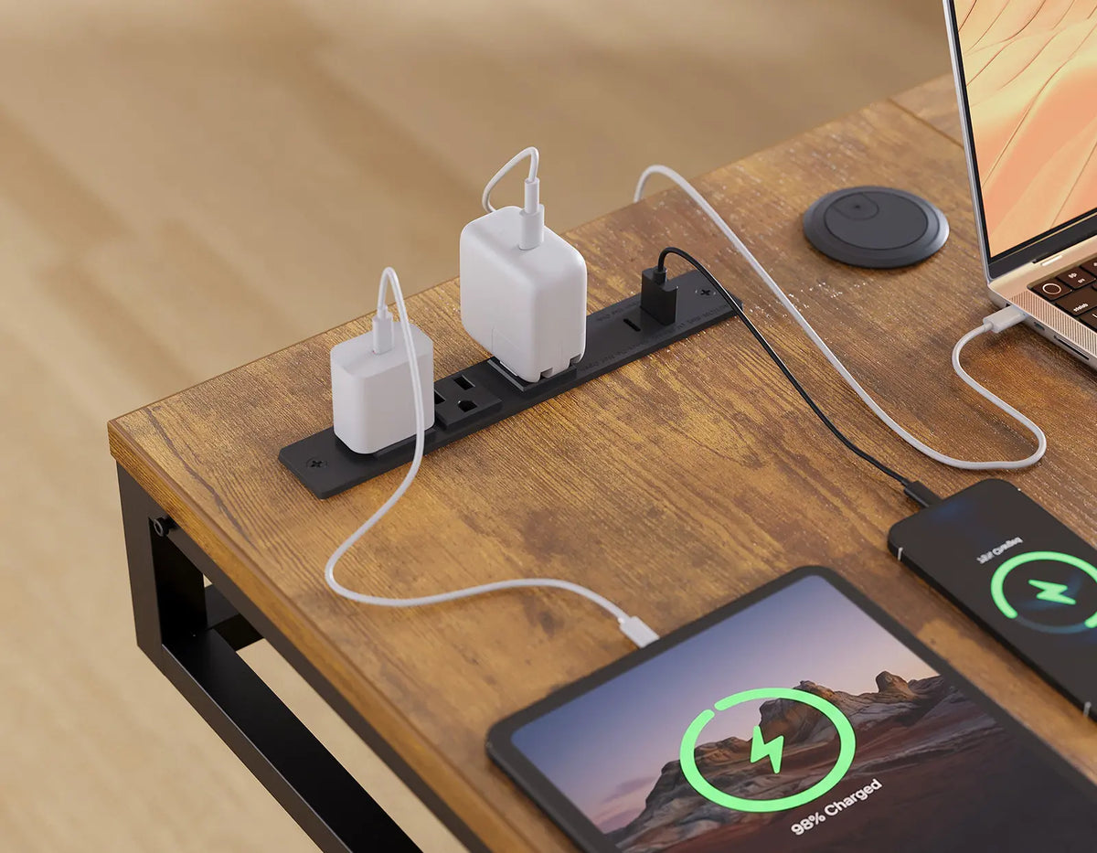Close-up of built-in power outlets on an OffiGo wood-look desktop, with cables connected to a laptop, tablet, and phone.