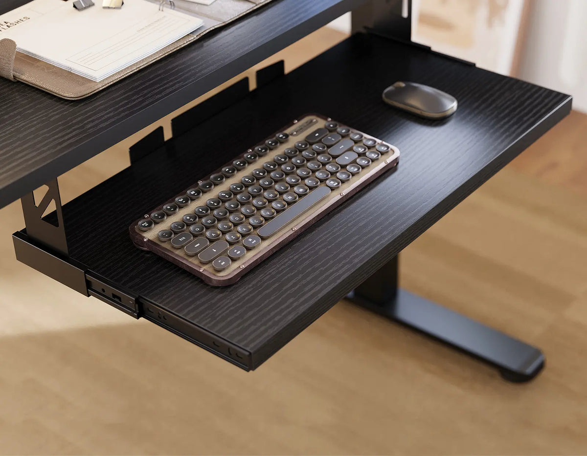 Close-up of an extended black keyboard tray beneath an OffiGo desk, holding a keyboard and mouse.