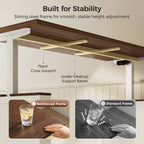 Underside of an OffiGo walnut-brown farmhouse standing desk, showing a fixed cross support and under-desktop support beam on the white frame, with reinforced and standard frame comparisons.